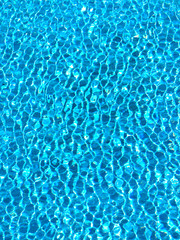 Azure ripples and shapes of water made on the surface of a swimming pool, suitable for a background. 
