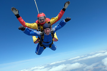 Skydiving. Tandem jump. Happy passenger and his instructor.