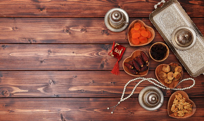 Ramadan concept. Delicious dates, dried figs, dried apricots, walnuts, almonds, raisins on bamboo...
