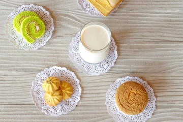 Milk Butter Bread Cake Roll Cookie and Cupcake on White Wooden Table