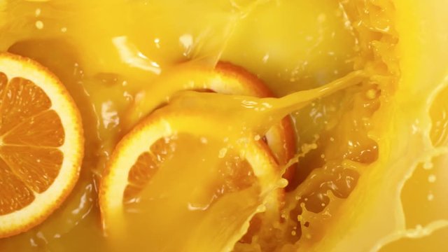 Super slow motion of orange slices falling into juice. Filmed on high speed cinema camera, 1000 fps.
