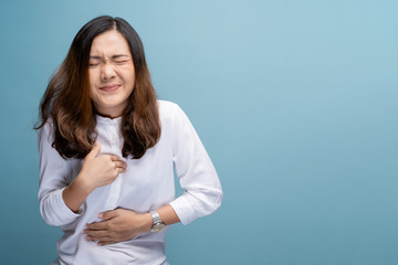 Woman has chest pain isolated over blue background - obrazy, fototapety, plakaty