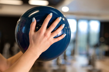 Beautiful young slim woman in sportwear doing some gymnastics at the gym with medball