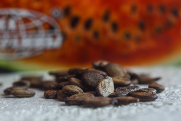 Obraz premium A heap of dried black watermelon seeds close-up on a white table background. planting season. close up top view copy space