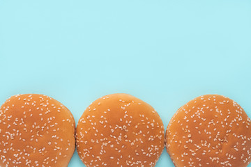 Burger buns on a blue background, top view. Flat lay, copy space.