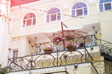 Beautiful balcony somewhere in southern Europe. Yellow house with flowers.