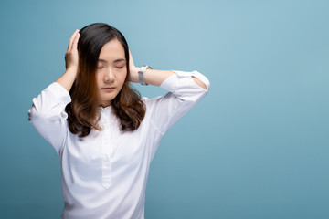 Woman covering her ears and standing isolated over blue background