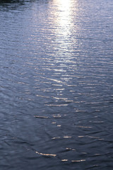 Sunset on the river, lake. The reflection of the sun in the water as in a mirror. Landscape background. Stock photo