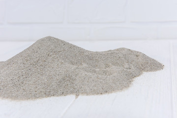 Fototapeta premium Sand on light wooden background close up