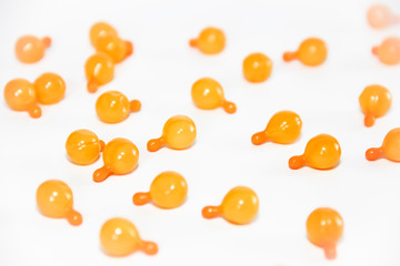 orange medical capsules with oil or medicine on a white background