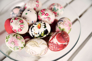 Colorful Easter eggs in bowl on white table
