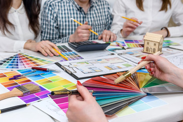 Group of creative designers working in office with color palettes