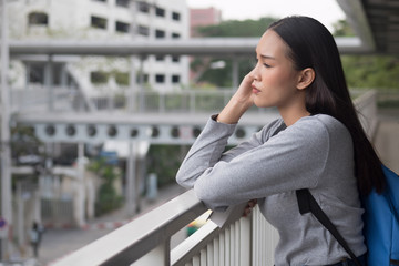 portrait of stressed, serious, pensive, thoughtful asian woman college student thinking in city...