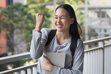 portrait of happy, smiling, successful, confident asian woman college student posing guts pose or...