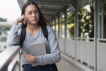 Fototapeta premium portrait of stressed, serious, pensive, thoughtful asian woman college student thinking in city campus environment