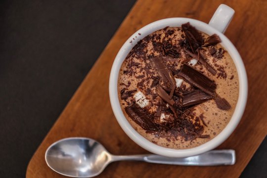 Hot chocolate milk on white mug in cafe