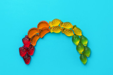 Colorful rainbow made from multicolored fruits gummy jelly candies strawberries oranges pineapples...