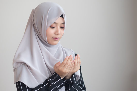 young modern asian muslim woman with islamic prayer hand; concept of Ramadan, Eid al Fitr, meditation, islamic praying, islam festival, muslim religious activities