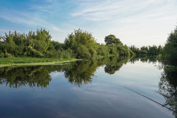Beautiful summer landscape with pretty river and colorful trees. View of the sky with beautiful clouds. Stock photo