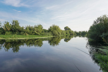 Beautiful summer landscape with pretty river and colorful trees. View of the sky with beautiful clouds. Stock photo