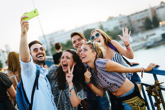 Happy young friends taking selfie on street