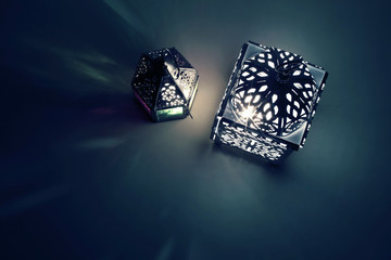 Silhouette of glowing Moroccan ornamental lanterns at night with decorative shadows. Greeting card,...