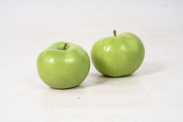 Two lovely green juicy apples on a white isolated background. Vegetarian food. Stock photo