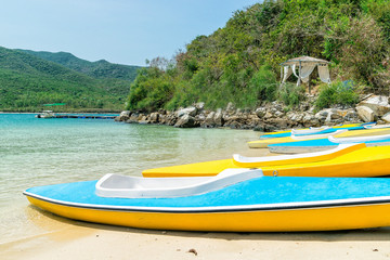 Fototapeta na wymiar Paradise beach on island with colorful kayayks on shore