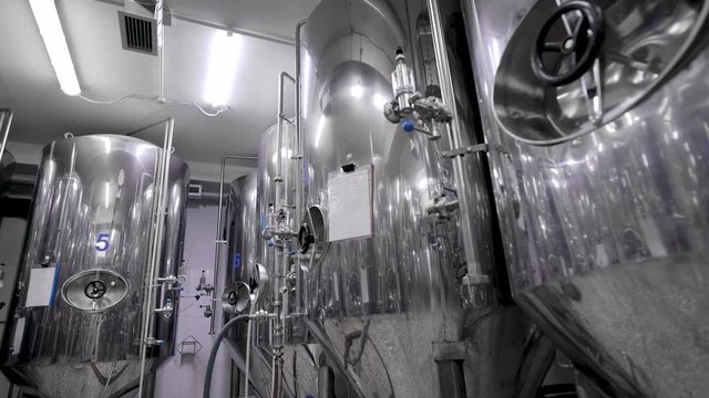 metal cisterns for mashing malt for beer are standing in shop of industrial brewery, round panoramic view