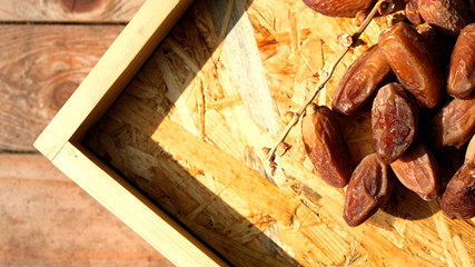 Dates in a wooden box under the afternoon sun