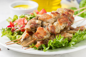 Meat kebabs (chicken, Turkey, pork) on wooden skewers with vegetable salad and yogurt sauce. Spring...
