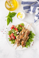 Meat kebabs (chicken, Turkey, pork) on wooden skewers with vegetable salad and yogurt sauce. Spring picnic, grilled food, delicious lunch