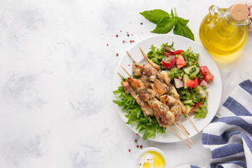 Meat kebabs (chicken, Turkey, pork) on wooden skewers with vegetable salad and yogurt sauce. Spring picnic, grilled food, delicious lunch