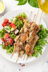 Meat kebabs (chicken, Turkey, pork) on wooden skewers with vegetable salad and yogurt sauce. Spring picnic, grilled food, delicious lunch