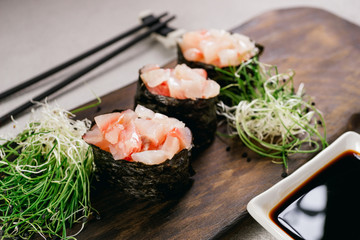Seafood delicatessen gunkan maki sushi rolls on wooden plate. Food blog and culinary, restaurant menu