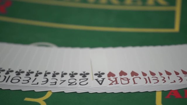 Dealer spreading the deck at poker game in casino