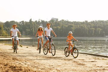 Family riding bicycles on embankment