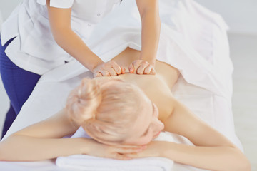 Obraz na płótnie Canvas Masseur does massage for a girl in a massage salon