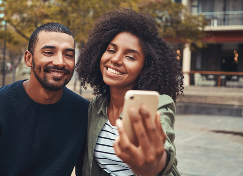 Smiling young couple taking selfie on smart phone