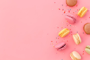 Brignt macarons for sweet break on pink background top view mock up