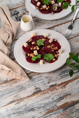 beetroot salad with goat cheese on a wooden rustic backdrop, copy space