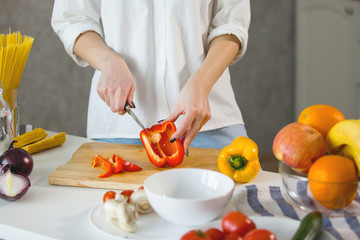 Obraz na płótnie Canvas Woman hands cutting vegetables in the kitchen.