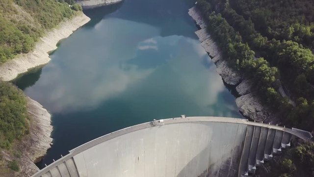 The majestic Verzasca dam, in Switzerland, blocks the great lake of Vogorno, nestled between the slopes of two mountains.