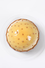 Contemporary Dome Mousse Cake covered with caramel mirror glaze, decorated with shortcrust cookies and walnuts, on white background.