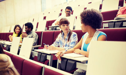 education, high school, university, learning and people concept - group of international students talking on lecture