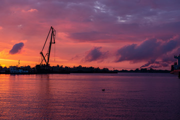 Obraz premium colorful sunset over the sea lake with dark red clouds