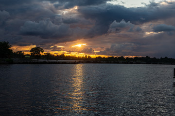 Naklejka premium colorful sunset over the sea lake with dark red clouds