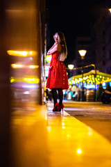 A mature woman checking the storefront at night