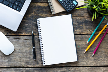 Empty notebook with smart phone and computer on wooden table top view.