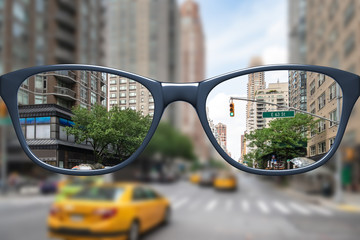 glasses with sharp and blurred big city - obrazy, fototapety, plakaty